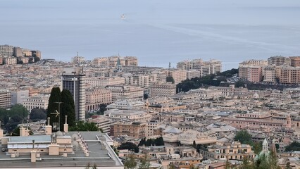 Genova, Italy - May 07, 2022: Panoramic  view from the sea to the old town, and the port with beautiful sunset. Genoa bay, harbor, yacht at the pier.tourist destinations.