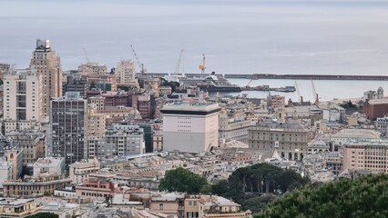 Genova, Italy - May 07, 2022: Panoramic  view from the sea to the old town, and the port with beautiful sunset. Genoa bay, harbor, yacht at the pier.tourist destinations.