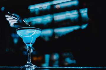 bartender at the bar or pub to prepare a cocktail Blue Lagoon