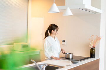 Obraz na płótnie Canvas おうちのキッチンで料理をする主婦