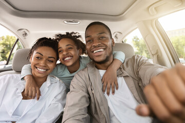 Cheerful Black Family Embracing Sitting In New Car On Vacation - obrazy, fototapety, plakaty