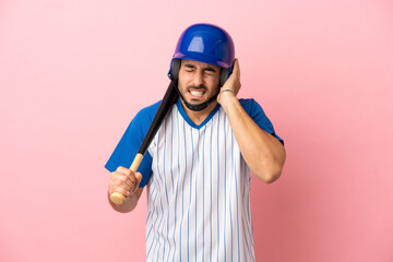 Baseball player with helmet and bat isolated on pink background frustrated and covering ears