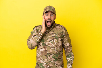 Military man isolated on yellow background with surprise and shocked facial expression