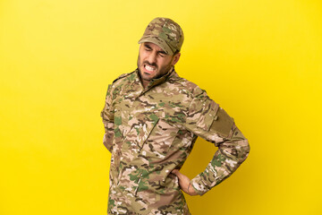 Military man isolated on yellow background suffering from backache for having made an effort