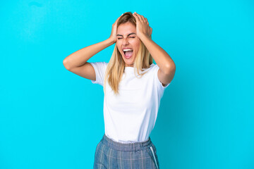 Blonde Uruguayan girl isolated on blue background stressed overwhelmed