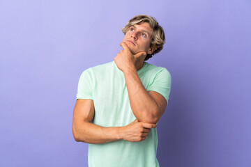 English man over isolated purple background having doubts