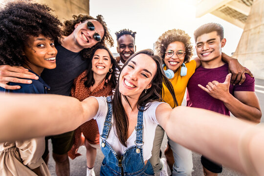 Multiracial group of friends taking selfie with smart mobile phone - Happy millenial people laughing together at camera - Different students having fun in college campus - Friendship concept