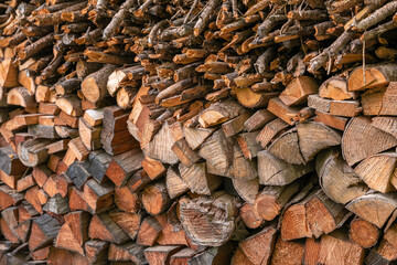Winter preparation. Stacking Firewood. Pile of firewood loggs. Firewood background. Dry chopped firewood logs in a pile.
