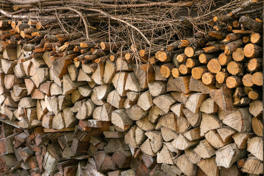 Winter preparation. Stacking Firewood. Pile of firewood loggs. Firewood background. Dry chopped firewood logs in a pile.