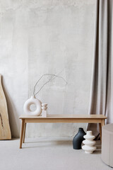Ceramic vases with branches in room with textured walls - obrazy, fototapety, plakaty