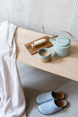 Vintage service set, cake and slippers on wooden table