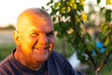 portrait of senior man with looking at camera in sunset and smiling. Horizontal shape, copy space.