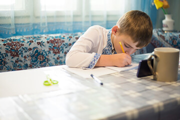 Ukrainian little boy studies online via smartphone