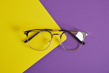 trendy eye glasses on a purple and yellow background glasses for study, computer work and reading