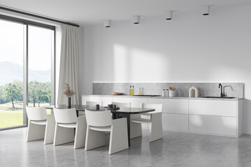 Light kitchen interior with table and seats, kitchenware and panoramic window