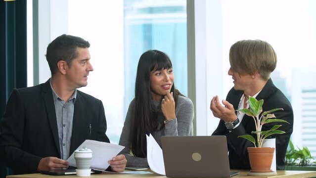 group of three business people meeting with paperwork and data in laptop computer on table in cafe over cityscape at high office . colleagues discussion in conference at meeting room