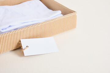 white cotton clothes in craft box and blank white paper label