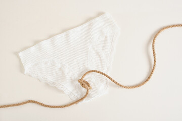 white female underwear panties and rope tied in a knot, women's health concept