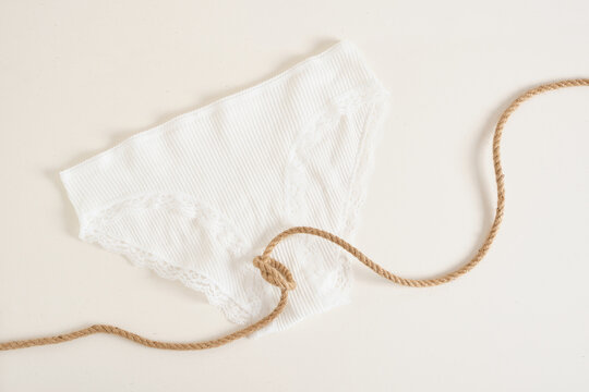 White Female Underwear Panties And Rope Tied In A Knot, Women's Health Concept