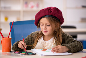 Young little girl enjoying painting at home