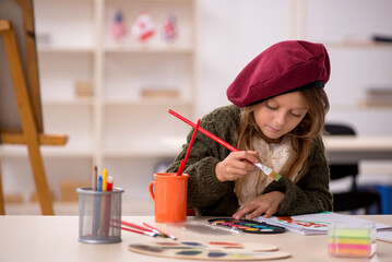 Young little girl enjoying painting at home