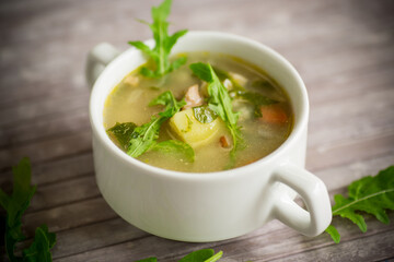 summer light soup with oatmeal and arugula in a plate