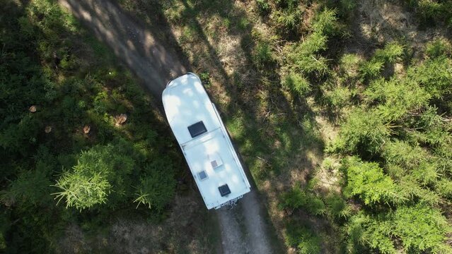 Class C Motorhome Camper Van on a Woodland Country Road Aerial View. Summer Vacation Road Trip.