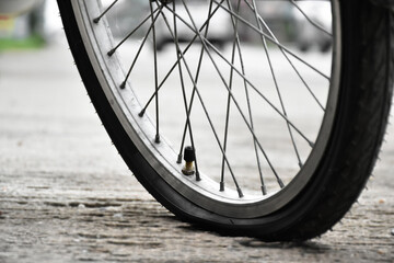 Fototapeta premium Closeup flat front wheel of vintage bike which parked on pavement, soft and selective focus.