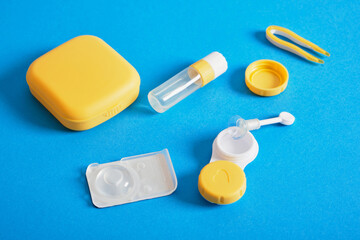 Contact lenses set, plastic case on blue background with copy space
