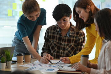 Portrait of Asian associate team brainstorming for document paper on the desk. Business and financial concepts.