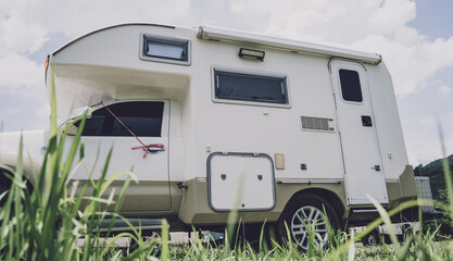 Travel camp trailer car with on the ground with grass