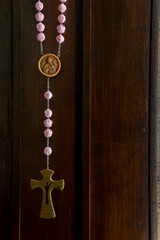 Rosary and cross on wooden background