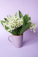 A bouquet of lilies of the valley stands in a circle on the background