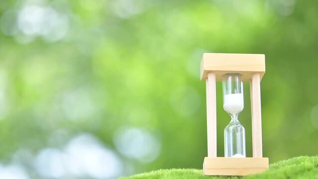 Hourglass on green grasses