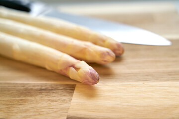 Peeled white asparagus on a kitchen table