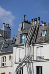 Fototapeta na wymiar The famous Parisian attics (mansard roofs) on the top floors of 19th-century Haussmann houses