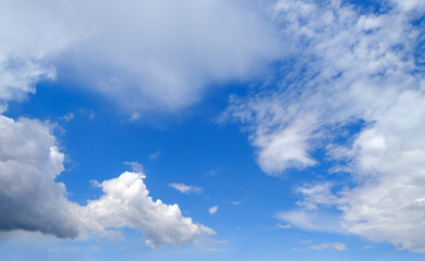 Naklejka na ściany i meble Fuffy clouds in blue sky. Summer good weather skyscape background.