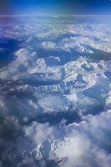 View of beautiful sky in sunny day above clouds with snow mountains from an airplane	
