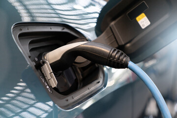 Close up of electric car with a connected charging cable 