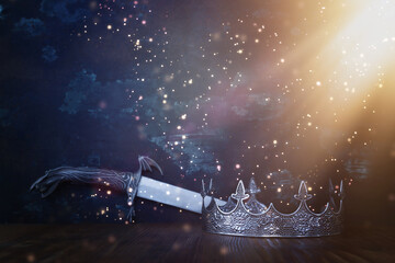 low key image of beautiful queen or king crown next to sword. fantasy medieval period. Selective...
