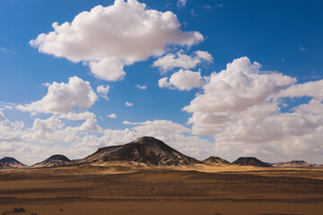 Fototapeta na wymiar Panoramic View to the Sandy Hills in the Black Desert, is National park in the Farafra Oasis, Egypt