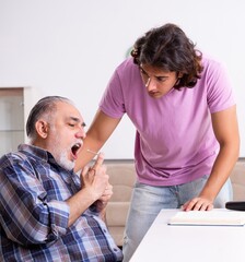 Young student and his old grandpa at home