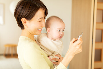 スマートフォンで動画を見る赤ちゃんと母親