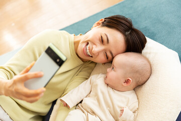 スマートフォンで写真を撮影する母親と赤ちゃん