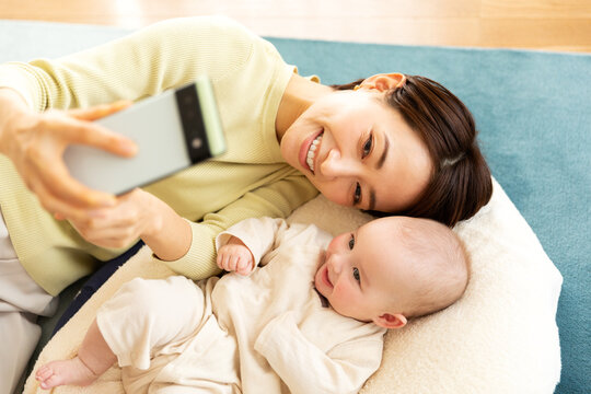 スマートフォンで写真を撮影する母親と赤ちゃん