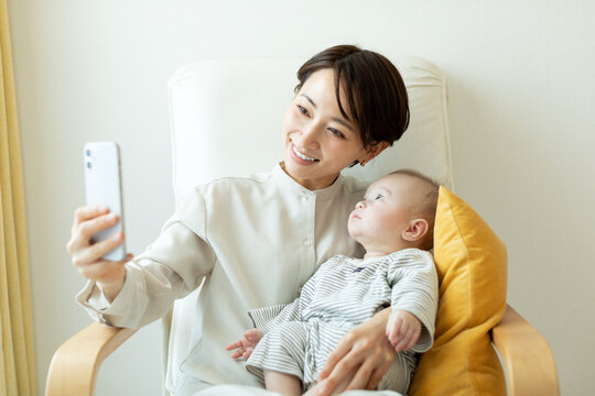 スマートフォンで写真を撮影する母親と赤ちゃん