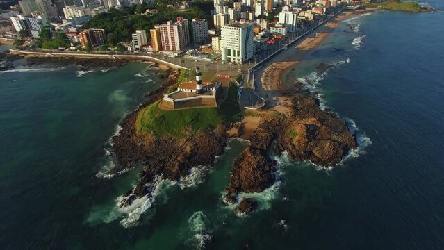 Aerial view of Salvador da Bahia, Brazil, tilt up shot showing historic Farol da Barra lighthouse and Salvador cityscape. 
