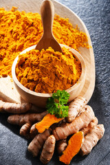 Composition with a bowl of ground turmeric and its fresh rhizome