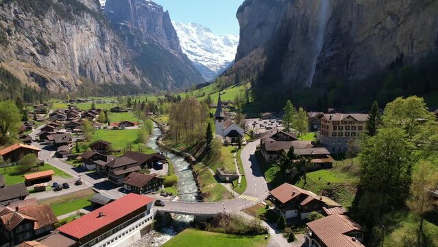 Switzerland nature and travel. Alpine scenery. Scenic traditional mountain village lauterbrunnen with waterfall  surrounded by snow peaks of Alps. Popular tourist destination and ski resort