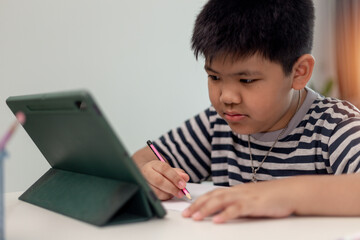 Kid self isolation using tablet for his homework,Child doing using digital tablet searching information on internet during covid 19 lock down,Home schooling,Social Distance,E-learning online education